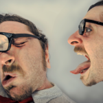 a photo of a Caucasian man in two images: on the right, it's him facing right 'yelling' with tongue out; on the left, it's him as if he had been hit, glasses askew and eyes shut