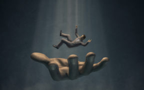 3D render of businessman in suit falling into large hand