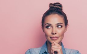 a woman looking like she's thinking against a pink background