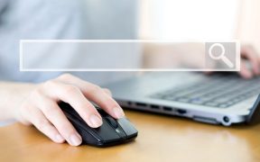 a photo of a person at a laptop with one hand on an external mouse. A graphic of a search box is superimposed over it