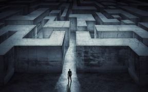 a graphic of a maze, with a silhouette of a man about to enter it