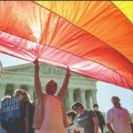 a photo of a group of people in front of a government building, holding the LGBT flag