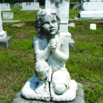 a photo of a cemetery, with an angel headstone center