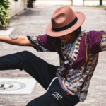 a man in a hat has his right foot up touching his hand in a stretch