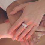 three hands clasped on top of each other