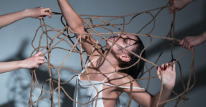 a young woman in a dancer outfit is underneath a rope net