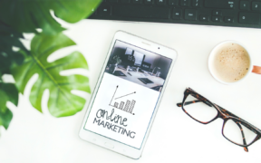 a keyboard at top, and bottom has a tablet showing 'online marketing', a cup of coffee, and glasses