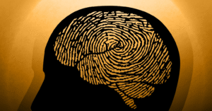 an illustration of an outline of a person’s head with a fingerprint pattern overlaid over their brain. Black illustration on a tan background.
