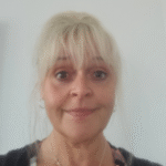 an older white woman with light blond (almost white) hair pulled up behind her