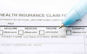 an insurance form with a blue pen placed on top